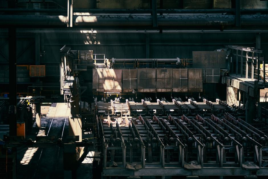 Arkistokuva: Suuri teollisuushalli, jossa on rivissä metallintyöstökoneita ja muita rakenteita; auringonvalo lankeaa korkeista ikkunoista.