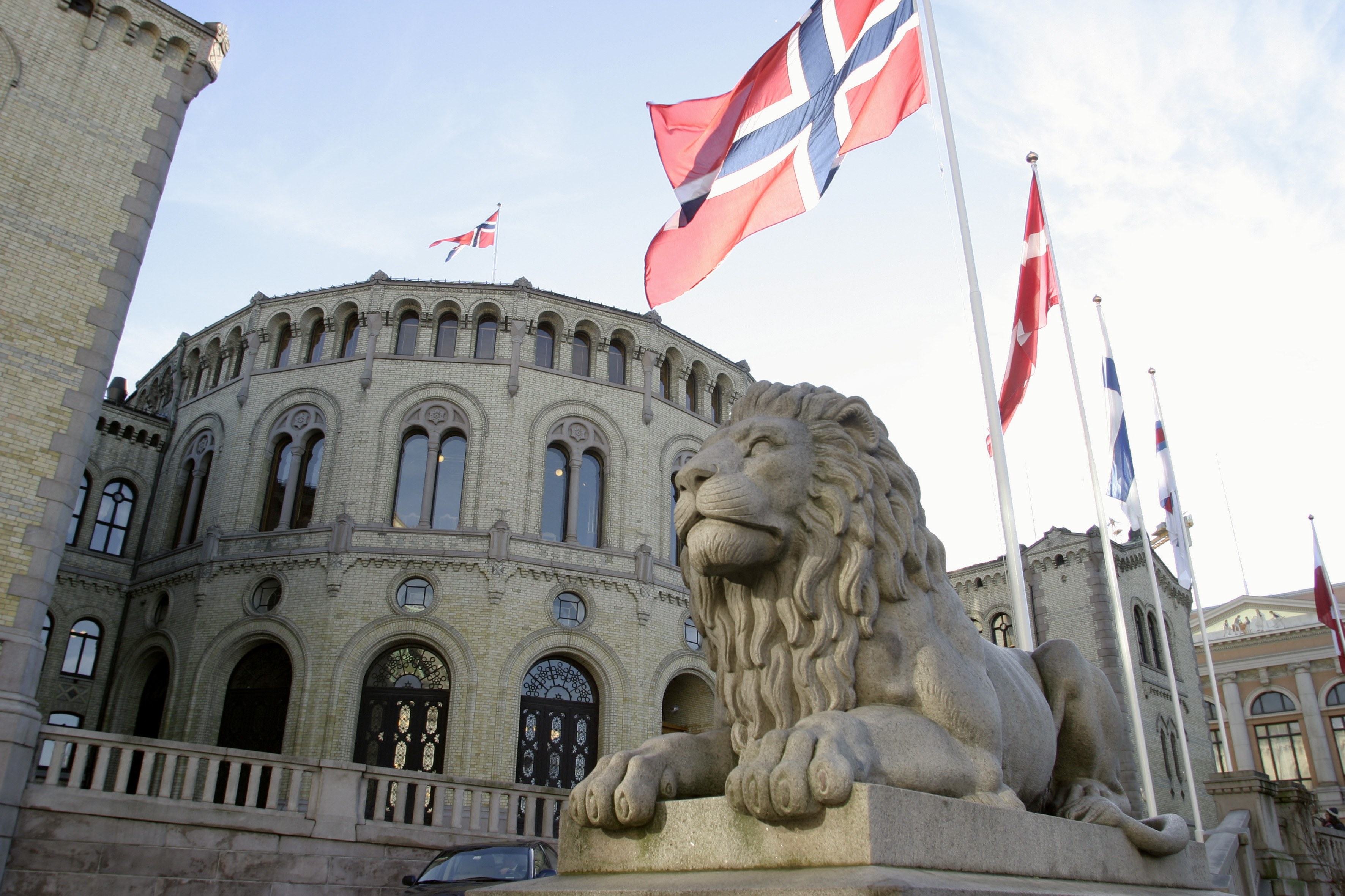 Arkistokuva: Pohjoismaiden lippuja salkoissa, kivinen leijonapatsas ja parlamenttitalon julkisivu.
