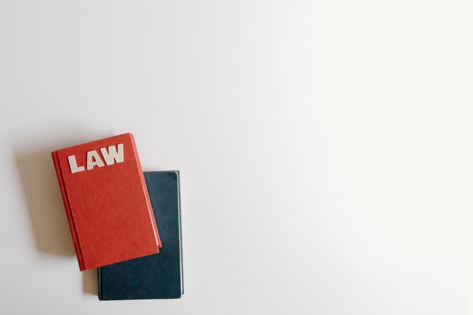 Arkistokuva: Punainen LAW-merkitty kirja on tummansinisen kirjan päällä valkoisella pinnalla.